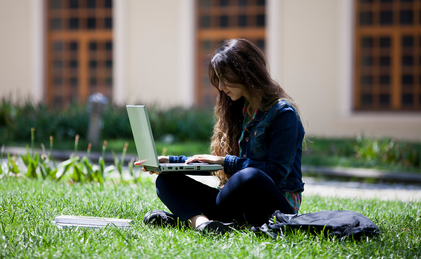 girl in grass with laptop